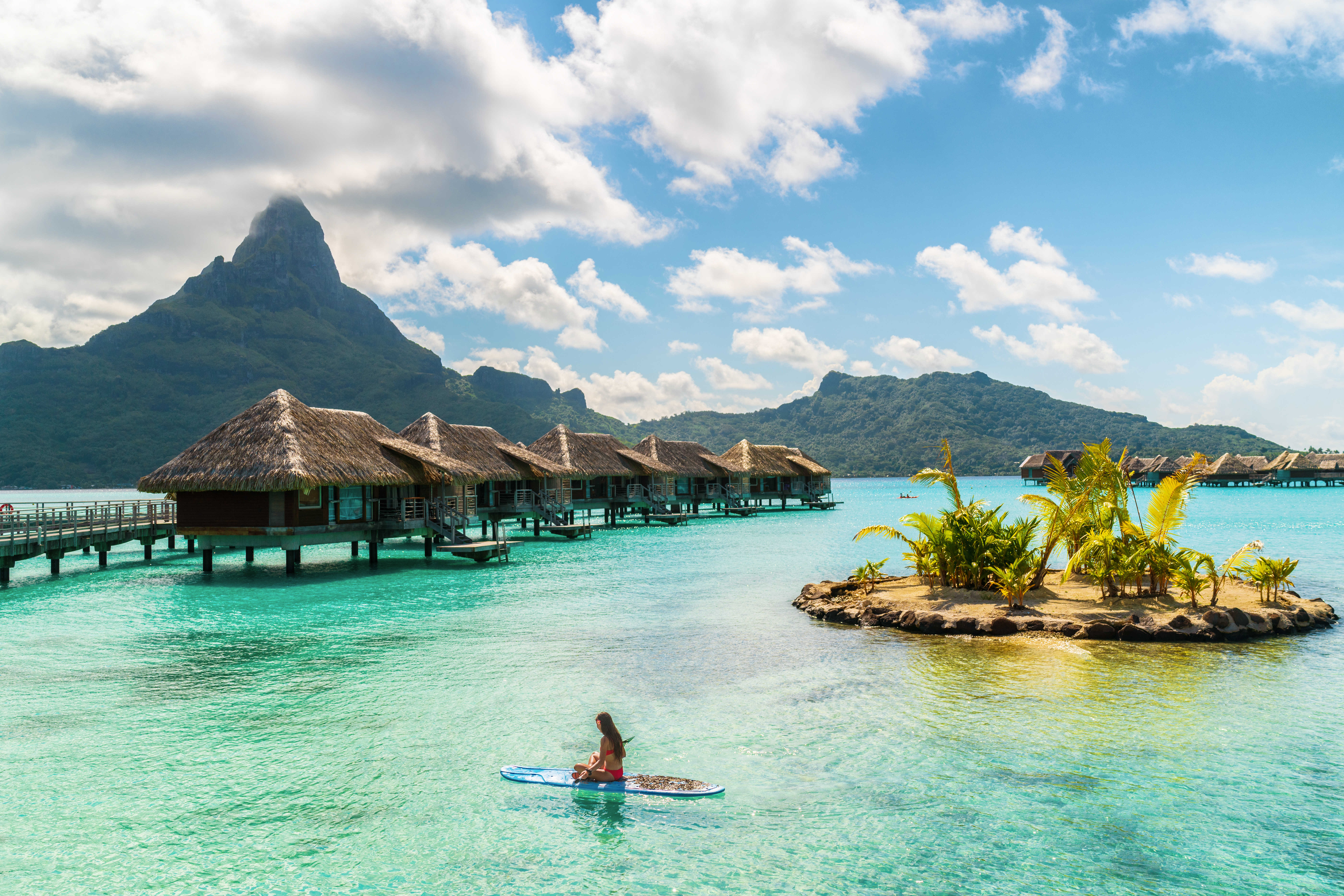 Tahiti luxury resort hotel in Bora Bora ,French Polynesia. Paddleboard leisure activity SUP paddle woman on active vacation in Tahiti, French Polynesia. Mount Otemanu summer holiday.
